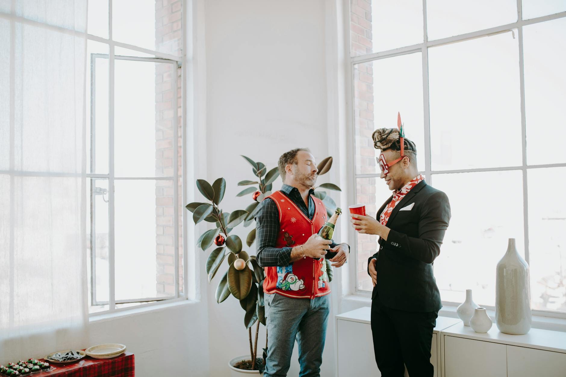 Dwoje współpracowników w świątecznych swetrach na biurowym przyjęciu