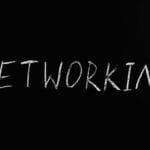 Napis networking kredą na czarnym tle nawiązuje do integracji firmowej