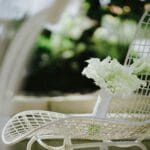 Biały ślubny bukiet oparty o nowoczesne krzesło