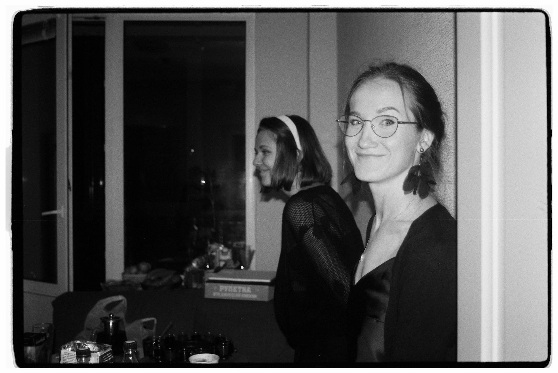 Dwie uśmiechnięte kobiety na domówce w klimacie silent disco