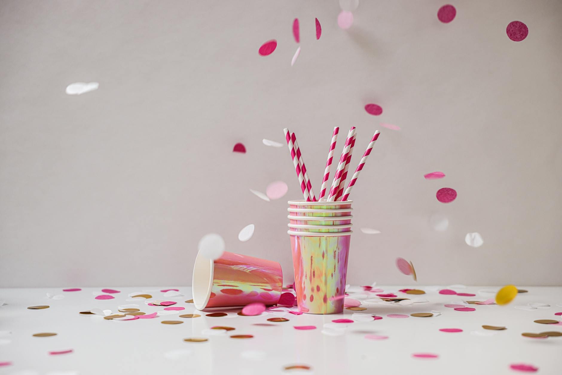 Kolorowe kubeczki, słomki i konfetti na białym tle imprezy