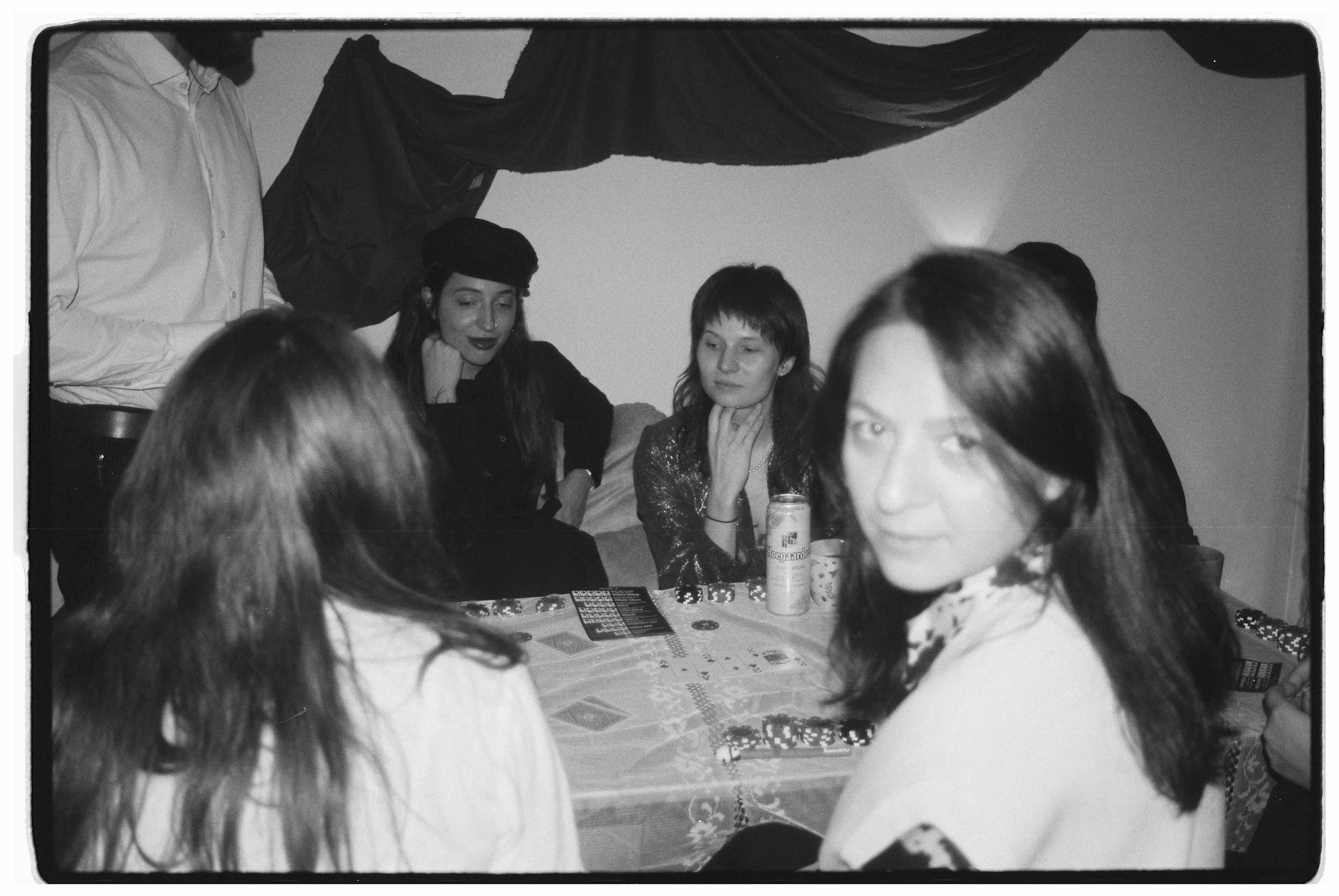 Przyjaciele przy stole w mieszkaniu szykują się do wspólnej domówki