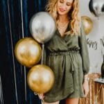 Uśmiechnięta kobieta z balonami na eleganckiej domówce sylwestrowej