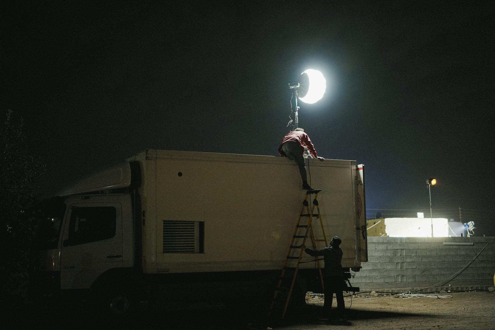 Ekipa filmowa montuje nocne oświetlenie na ciężarówce