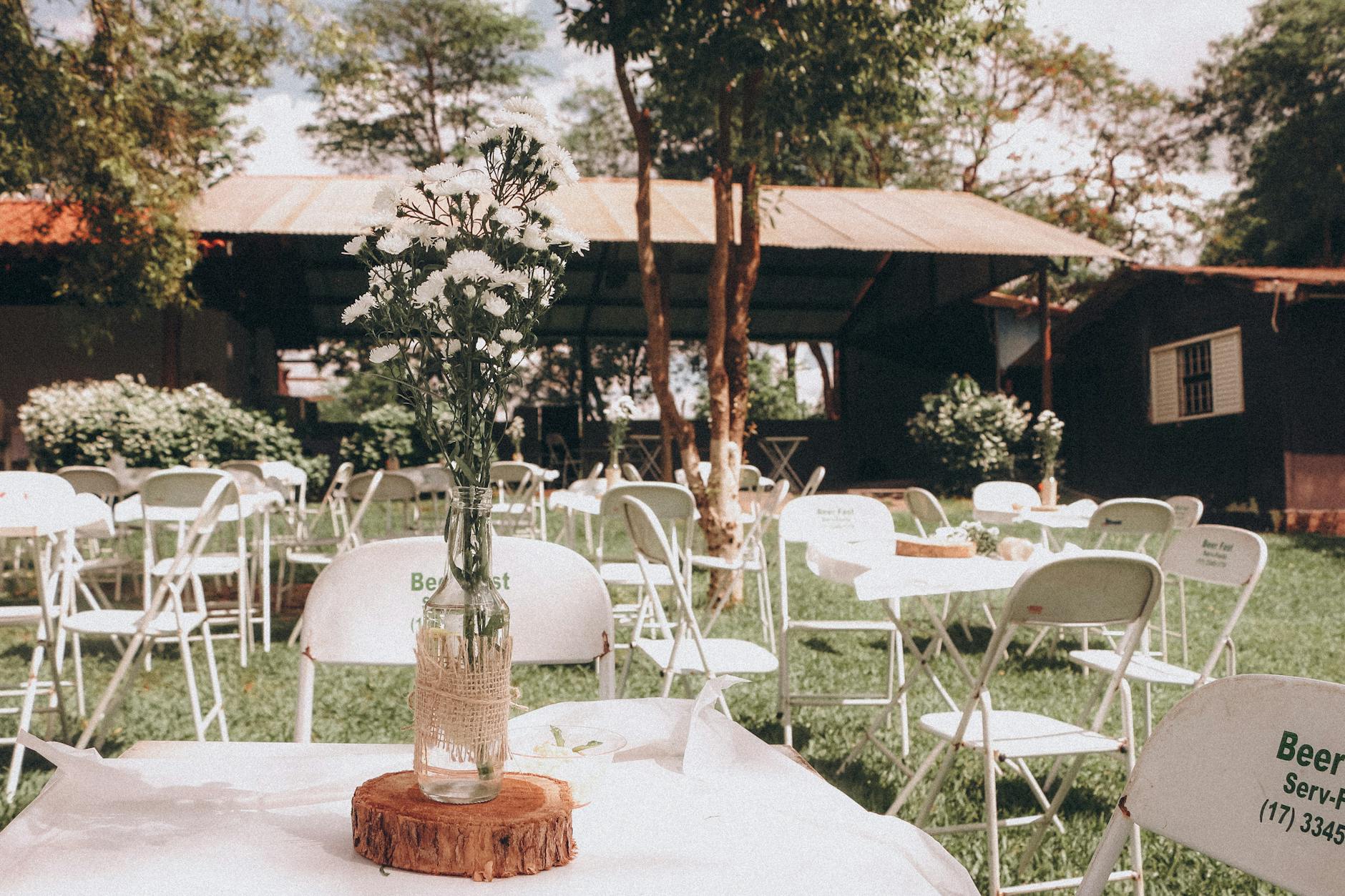 Plenerowa aranżacja ogrodowa z kwiatowym centrum stołu na event