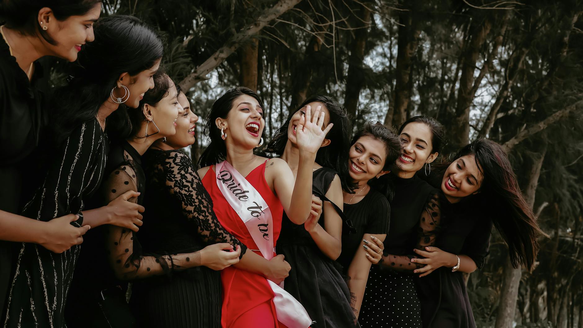 Przyszła panna młoda z szarfą świętuje wieczór panieński z druhnami na dworze