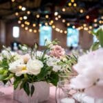 Weselna kompozycja z róż na środku udekorowanego stołu