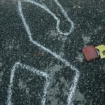 Zarys ciała kredą i znacznik dowodów na asfaltowym miejscu zbrodni