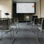 Pusta sala konferencyjna z krzesłami i ekranem do prezentacji